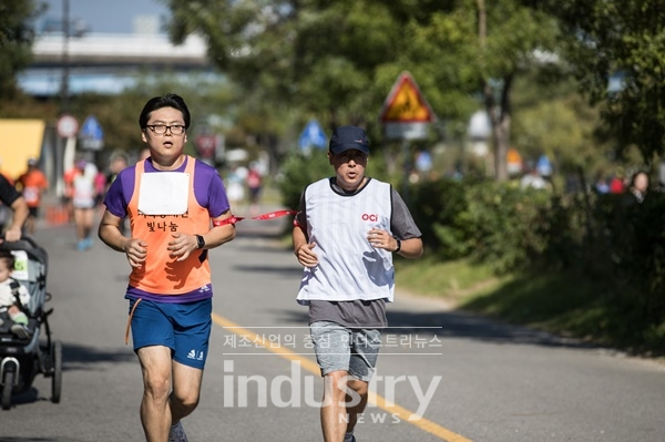 시각장애인 마라토너와 달리기 도우미인 OCI 직원이 함께 10km를 완주하고 있다. [사진=OCI]