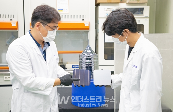 이진석 책임연구원(왼쪽)과 이준규 연구원이 태양광 폐패널로부터 회수한 실리콘을 재활용해 만든 웨이퍼와 태양전지를 들고 있다. [사진=한국에너지기술연구원]