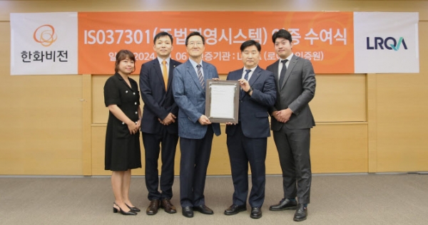 안순홍 한화비전 대표이사(왼쪽에서 세번째), 이일형 로이드인증원 대표이사(왼쪽에서 네번째)가 규범준수경영시스템 ‘ISO 37301’ 인증서를 들어 보이고 있다/사진 = 한화비전