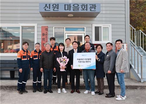 포스코1%나눔재단 광양시 신원 마을회관 희망공간 현판식에서 관계자들이 팻말과 화환을 들고 있다/사진 = 포스코