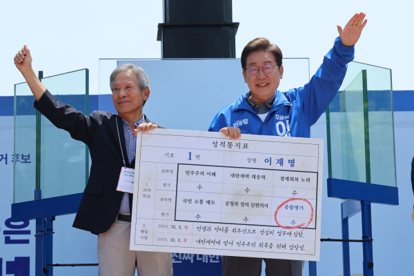 더불어민주당 이재명 대선 후보가 선거를 이틀 앞두고 '험지 공략'에 나선 1일 고향인 경북 안동시의 웅부공원에서 열린 유세에서 이 후보의 초등학교 은사인 박병기 선생님으로부터 대선 후보 모의 성적 통지표를 받고 있다. /사진=연합뉴스