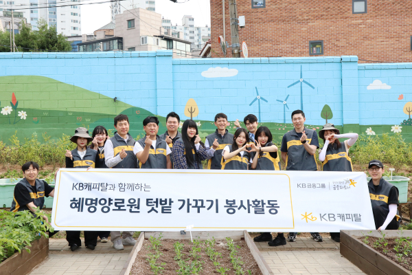 KB캐피탈 임직원들이 2일 금천구 혜양로원에서 텃밭 가꾸기 및 식수 봉사활동 진행한 뒤 손으로 하트를 만들어 보이고 있다. / 사진 = KB캐피탈