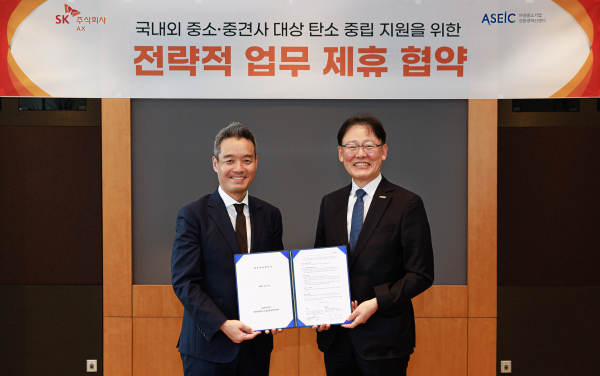 김민혁 SK AX 글로벌·제조사업부문장(왼쪽)과 ASEIC 정광천 이사장이 경기도 성남시 분당구 SK AX 본사에서 '국내외 중소∙중견기업 대상 탄소 중립 지원을 위한 전략적 업무 제휴 협약식'을 체결하고 협약서를 들어 보이고 있다./사진=SK AX